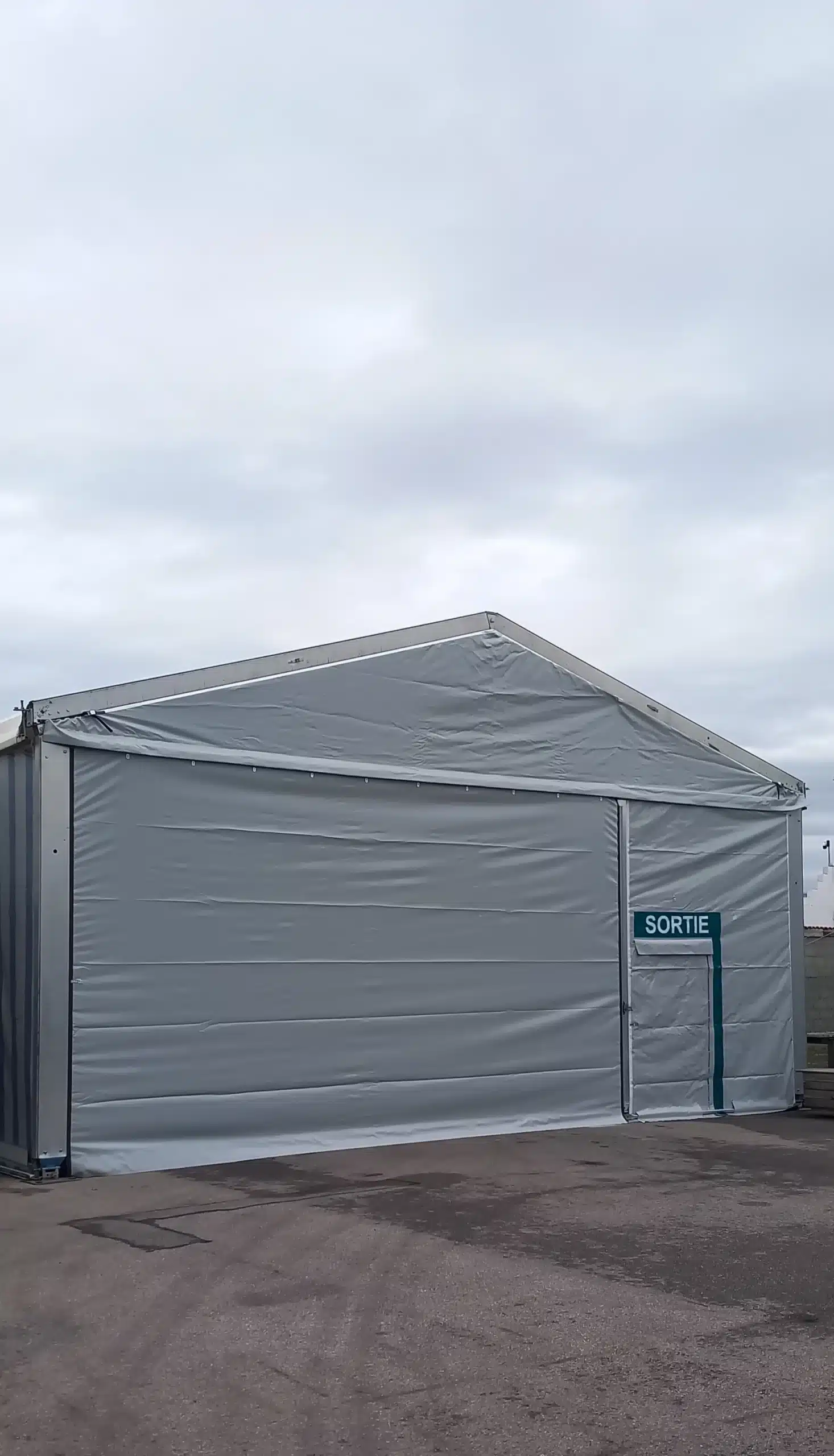 Chapiteau sur mesure en location longue durée avec porte de sortie et bardage location chapiteaux